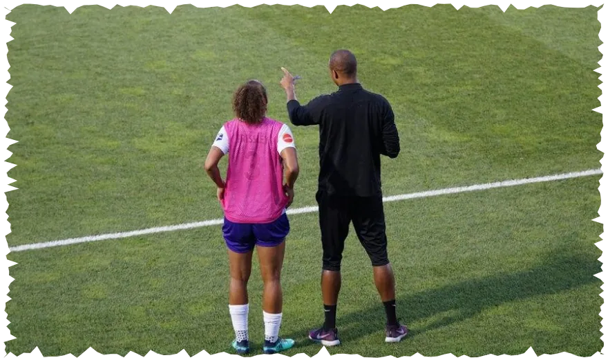 Coach talking to a young player on the sideline